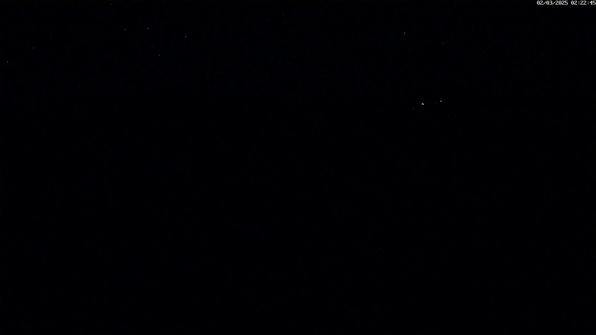 A mostly clear night sky shows a few faint stars.