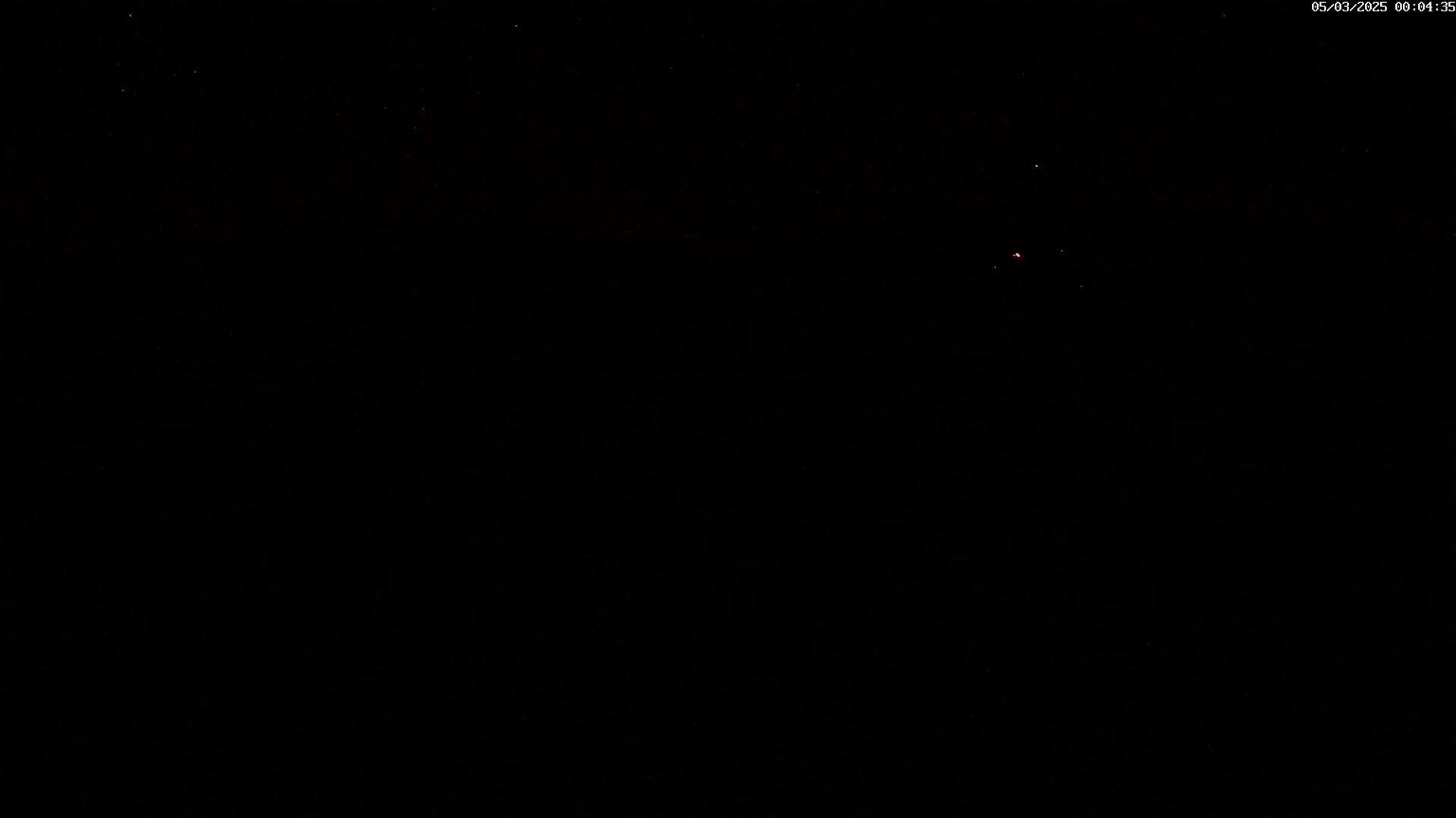 A mostly clear night sky shows a few faint stars.