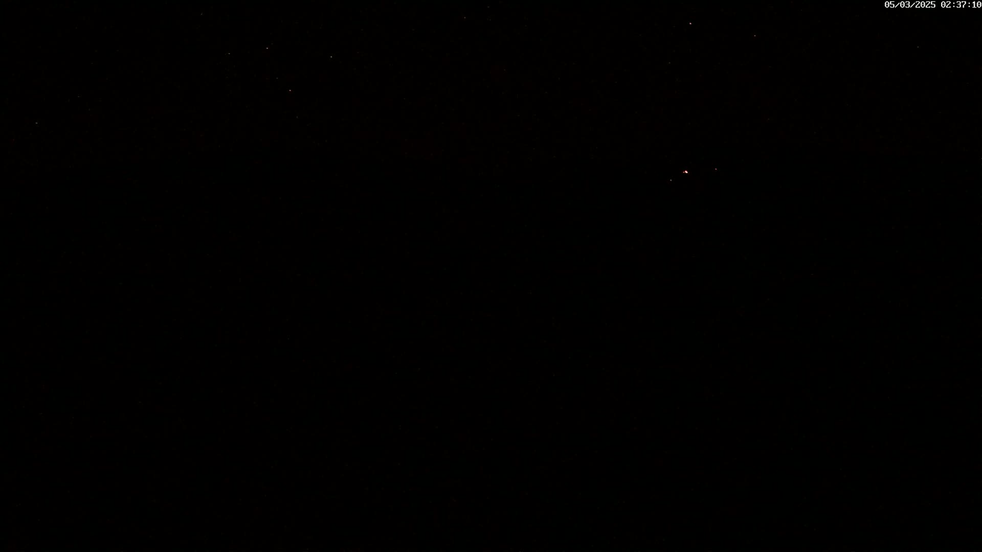 A nighttime image shows a dark sky with a few faint stars visible.