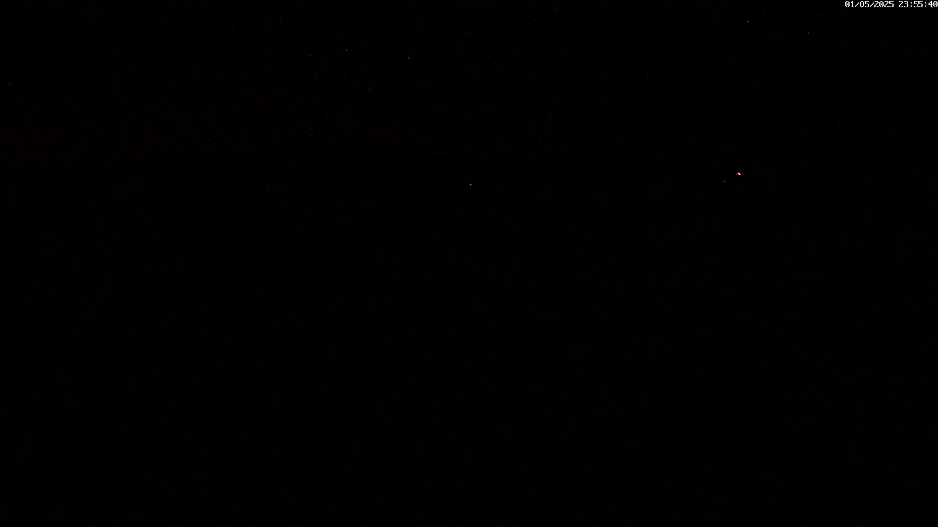A nearly completely black nighttime sky shows a few faint stars.