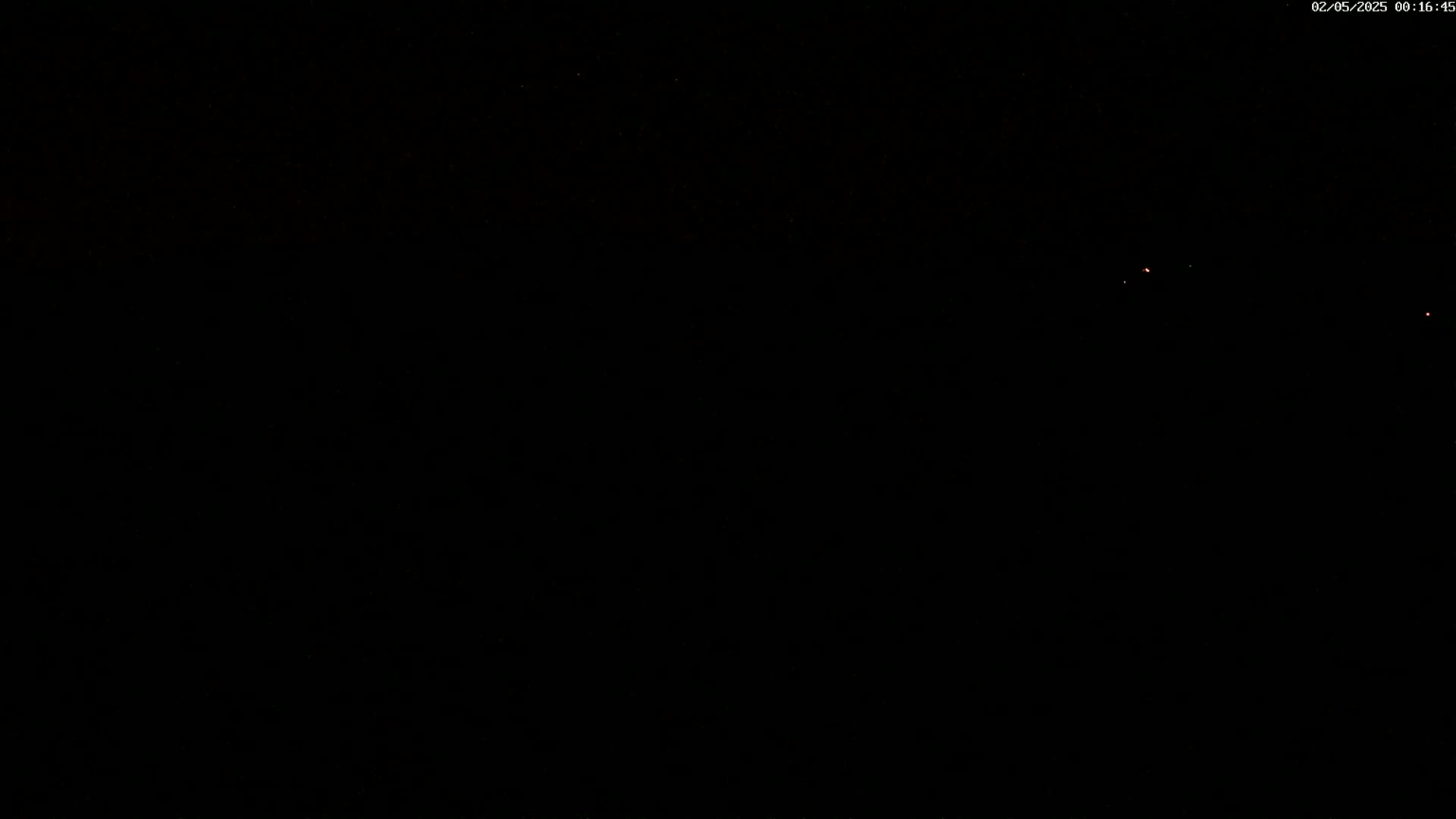 A dark, nighttime scene shows a few faint, distant lights in the sky.