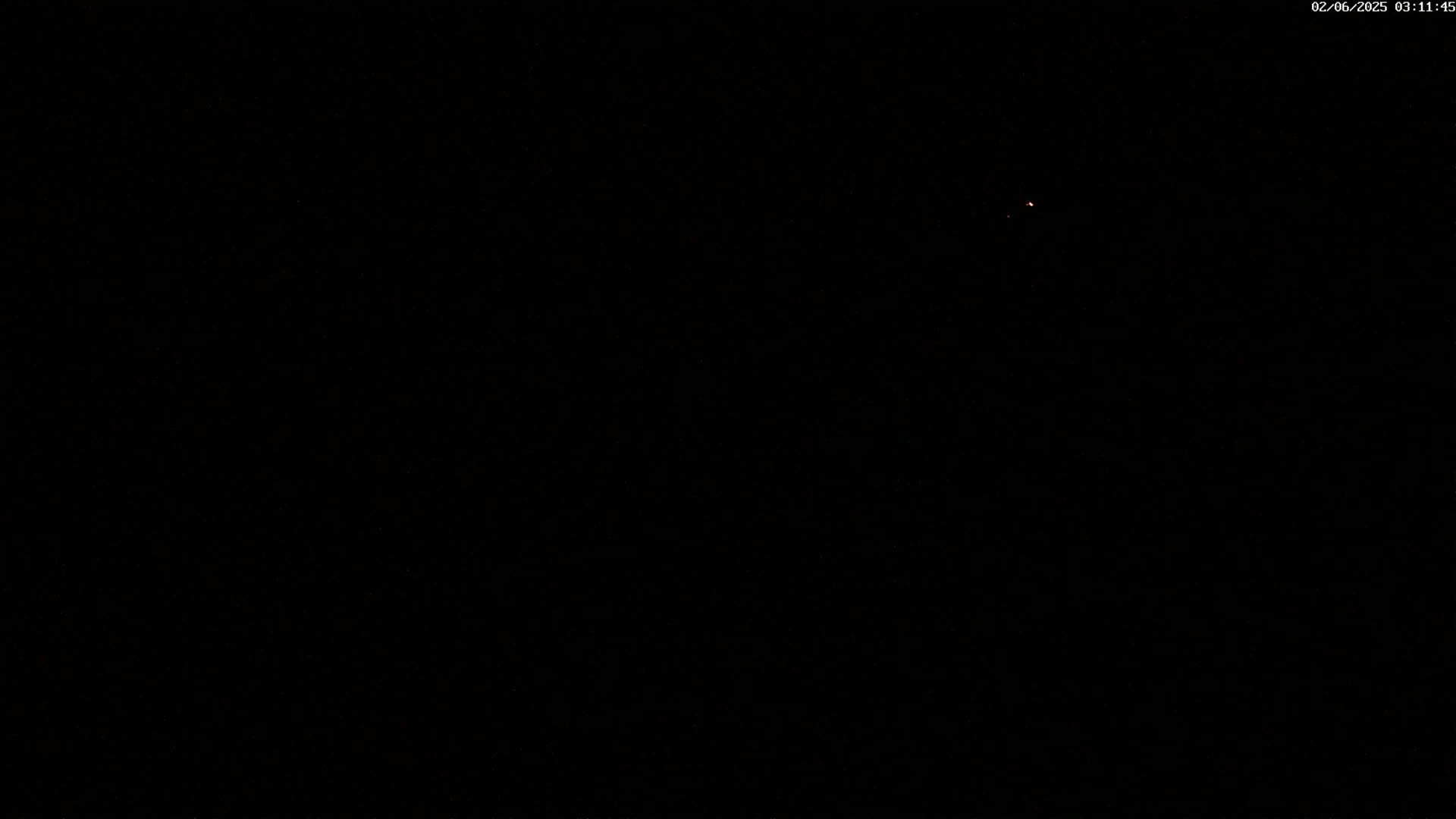 A dark night sky shows a single, faint light.