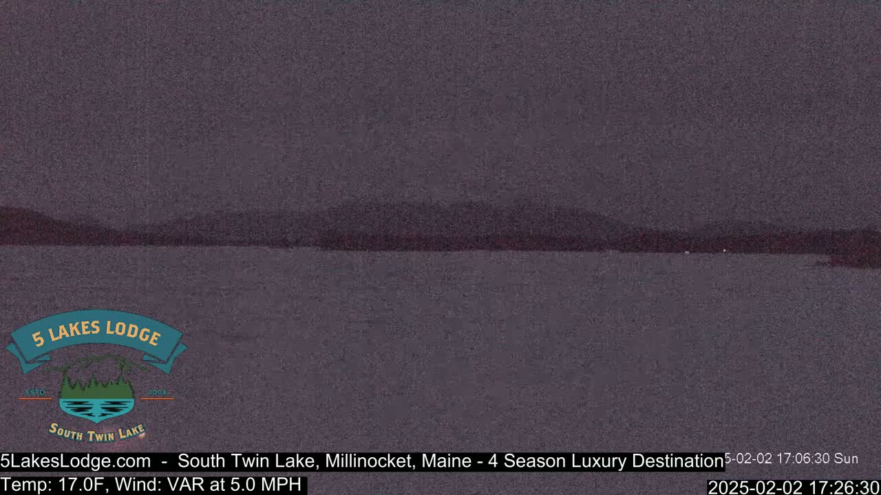 A dark, still lake is visible under a dusky sky with a distant, dark shoreline.