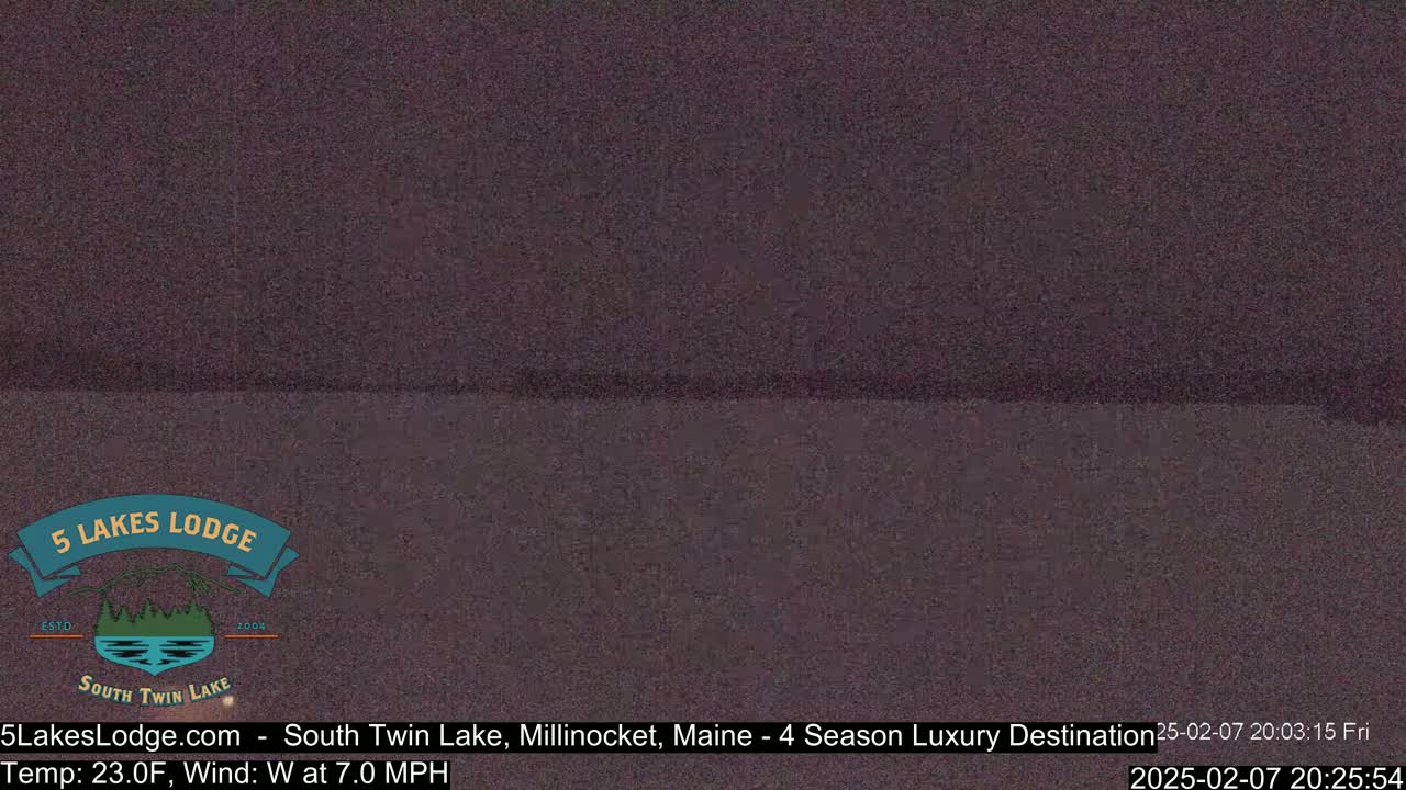 A dark, blurry view of a body of water at night, under a dark sky.
