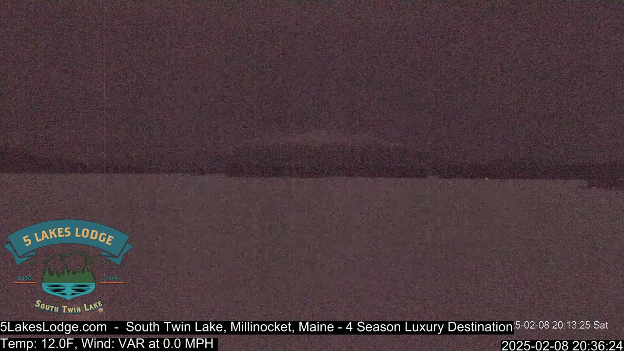 A dark, blurry image shows a body of water under a dark sky at 12 degrees Fahrenheit with a variable wind at 0.0 mph.