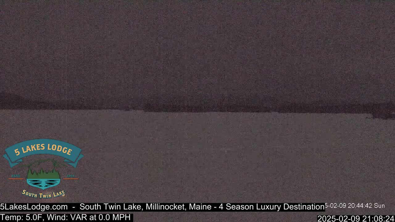 A dark, possibly nighttime, image shows a body of still water under a dark sky.