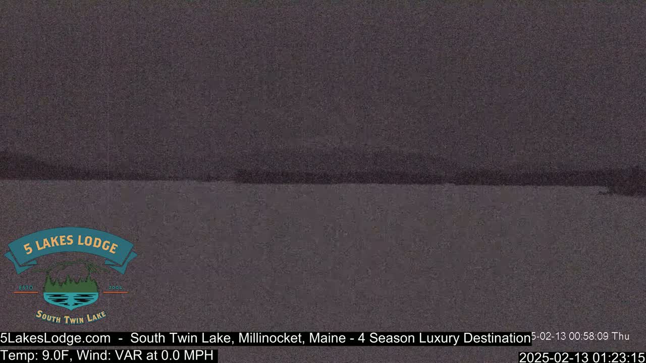 A dark, still body of water is visible under a gloomy sky.
