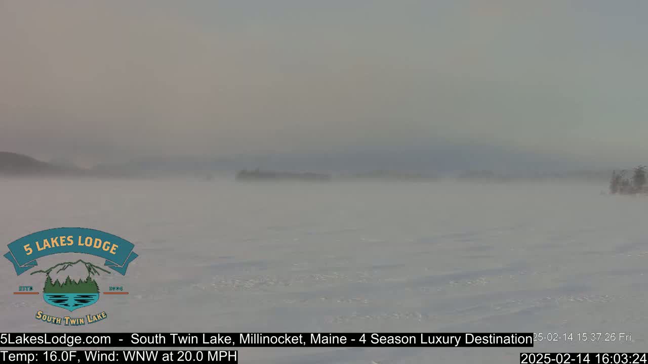 A snow-covered lake is visible under a hazy sky with a 20 mph wind.