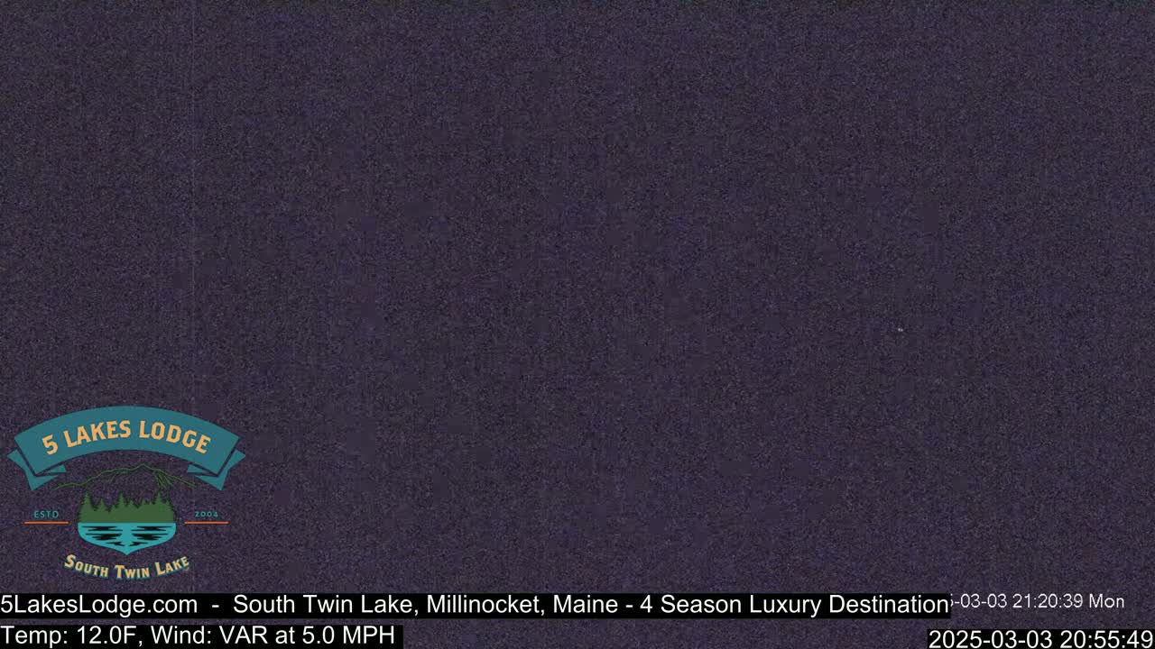 A dark, grainy image of a nighttime outdoor scene shows a mostly featureless view under a dark sky.
