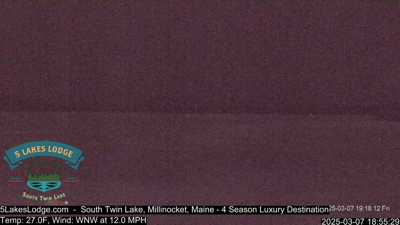 A dark, blurry image of a nighttime outdoor scene shows a body of water under a dark sky.