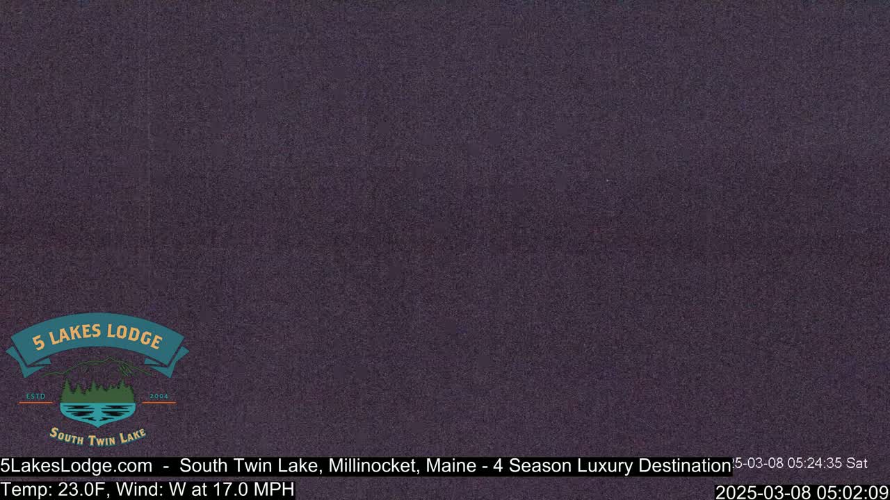 A dark, blurry image of a nighttime scene, possibly outdoors with a 23°F temperature and a 17 mph west wind.