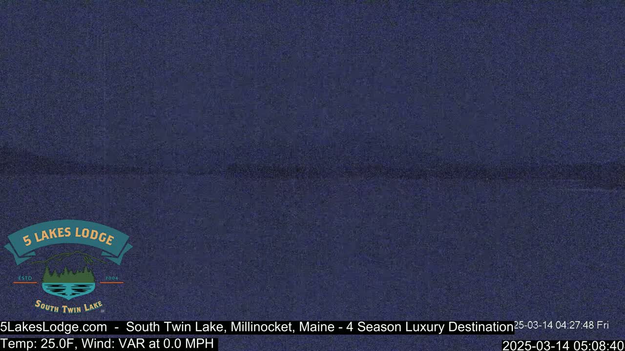 A dark blue, nighttime image shows a still body of water under a clear sky.
