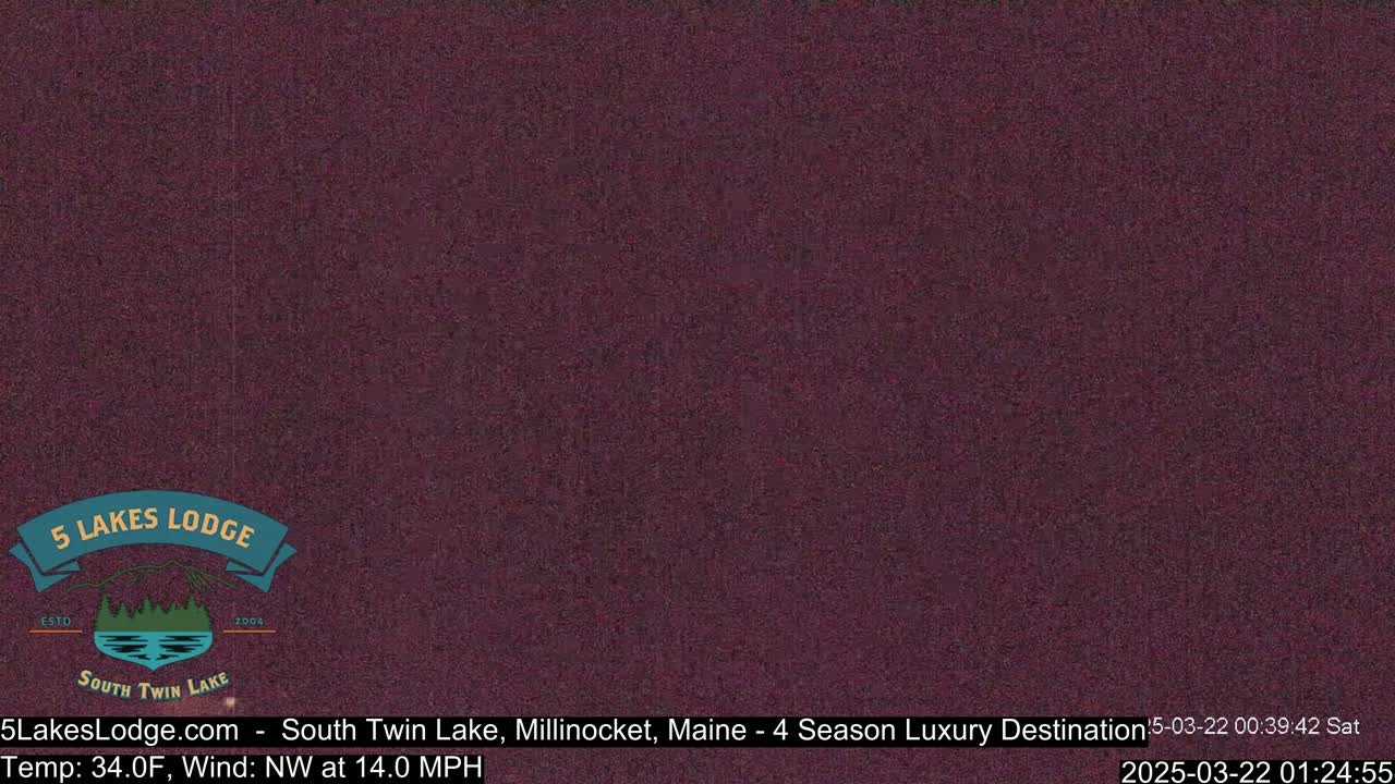 A dark purple, grainy image shows a nighttime outdoor scene with a northwest wind at 14 mph and a temperature of 34 degrees Fahrenheit.