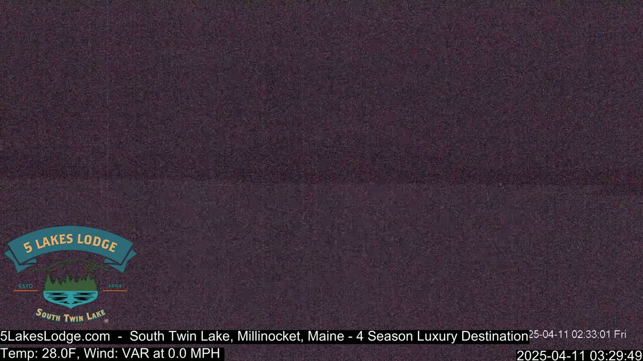 A dark, grainy image shows a nighttime view of a still body of water.