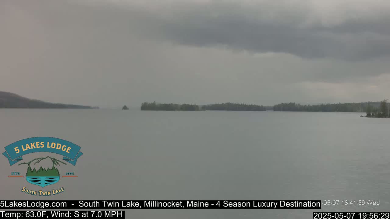 A calm lake is shown under an overcast sky.