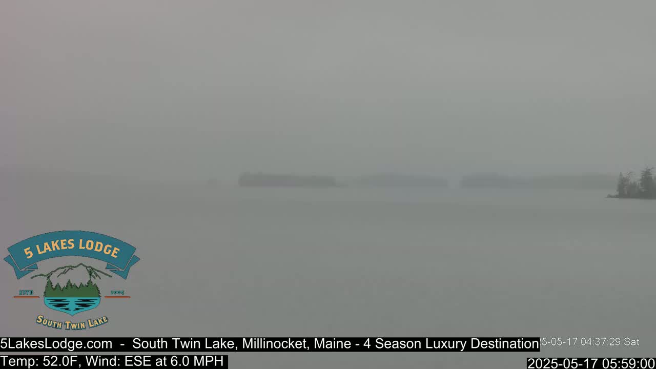 A hazy, gray view of a lake with small, distant islands under overcast conditions.