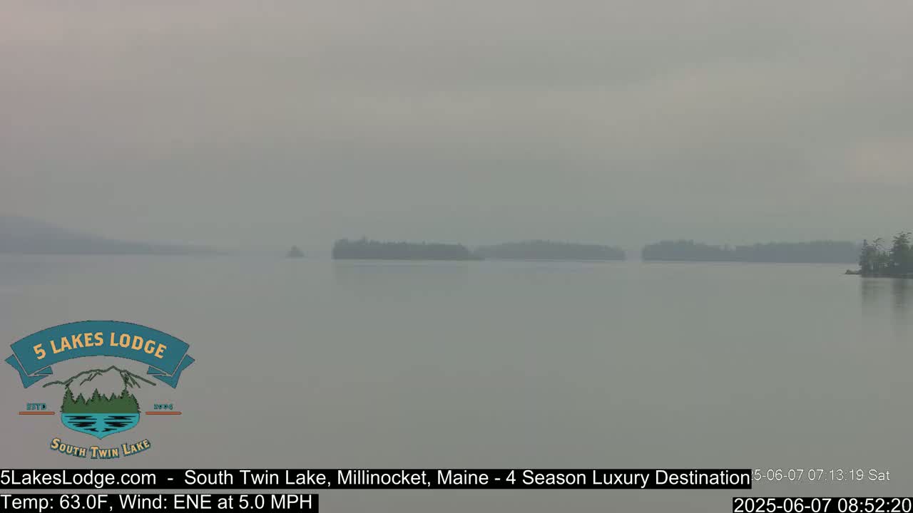 A hazy view of a lake with several small, wooded islands in the distance.