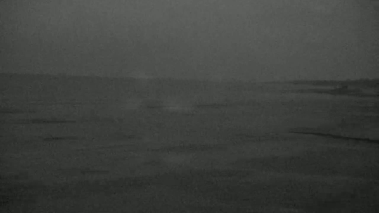 A dark, hazy landscape stretches out under a gloomy sky.