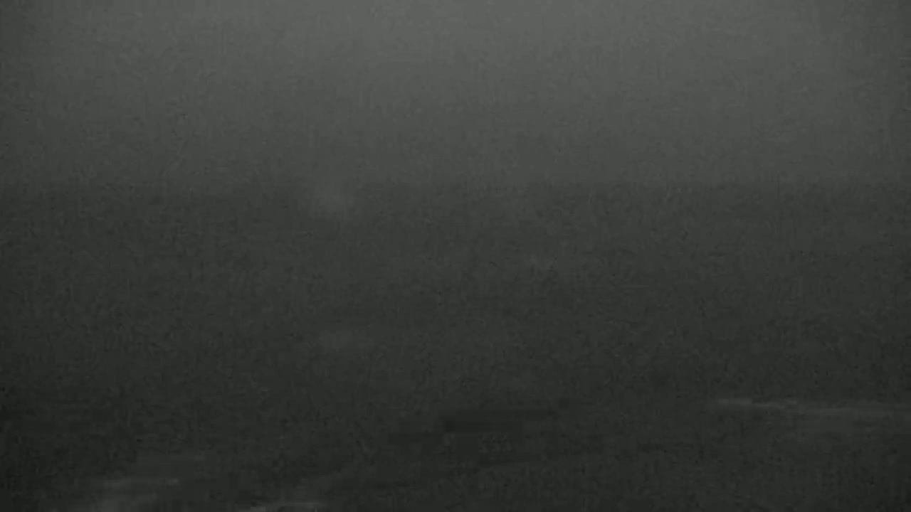 A dark, hazy landscape is visible under a heavy fog or dust storm.