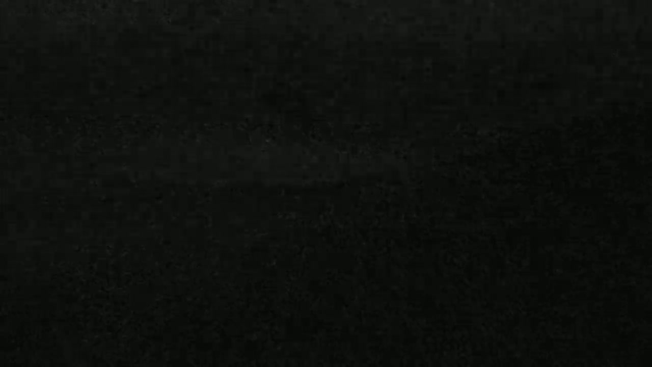 The image shows a dark, textured surface that appears to be a close-up of a dark-colored material.