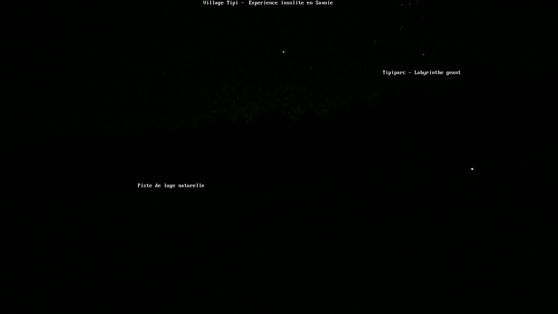 A nighttime view shows a dark forest silhouetted against a mostly clear, starlit sky.