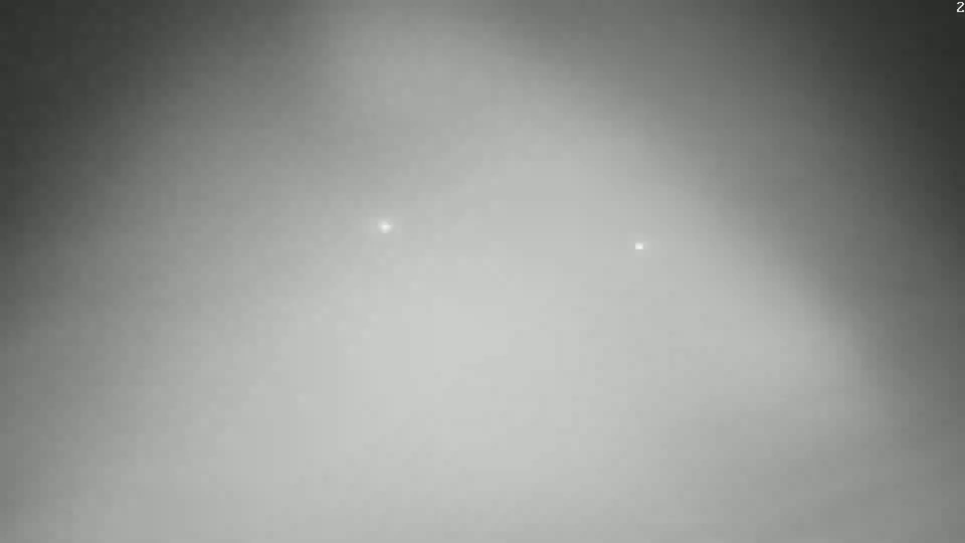 A hazy, gray sky shows two faint, distant lights.