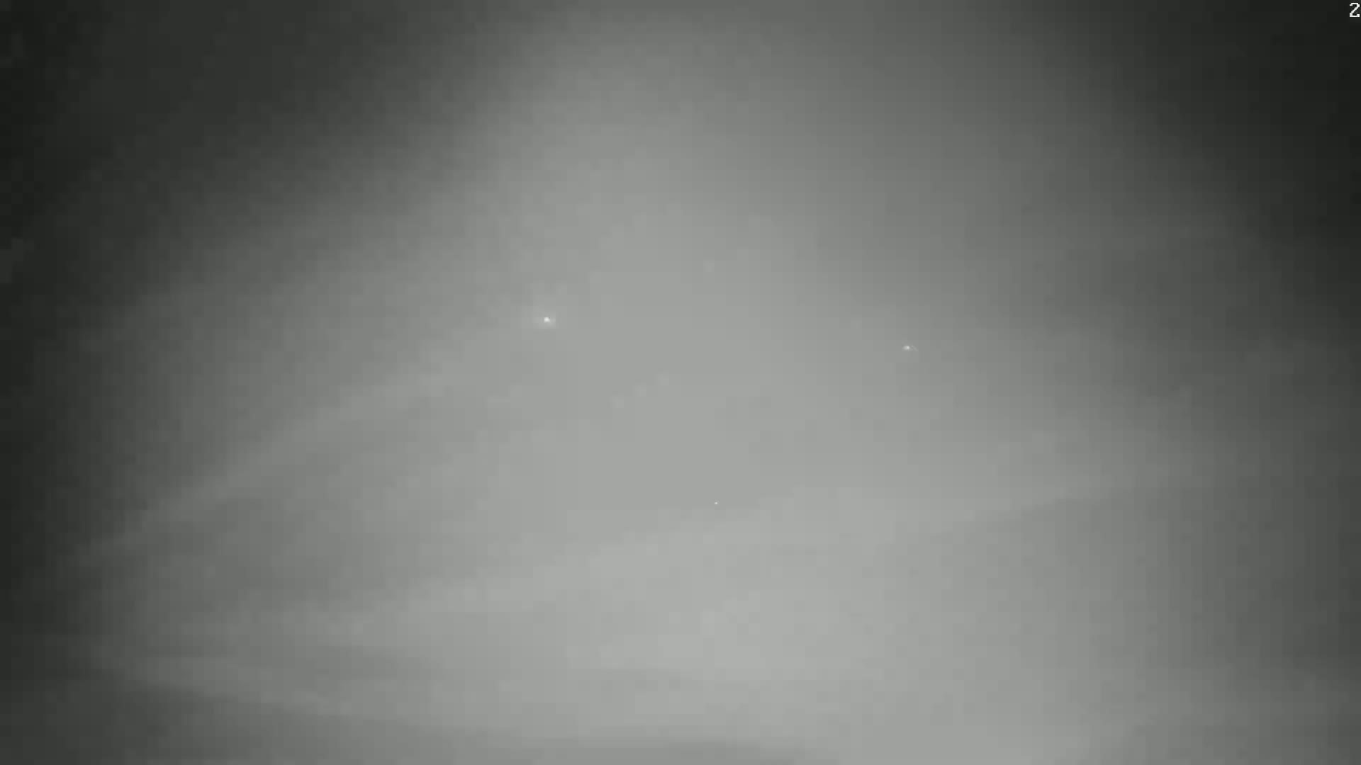 A hazy, gray sky shows a few faint lights.