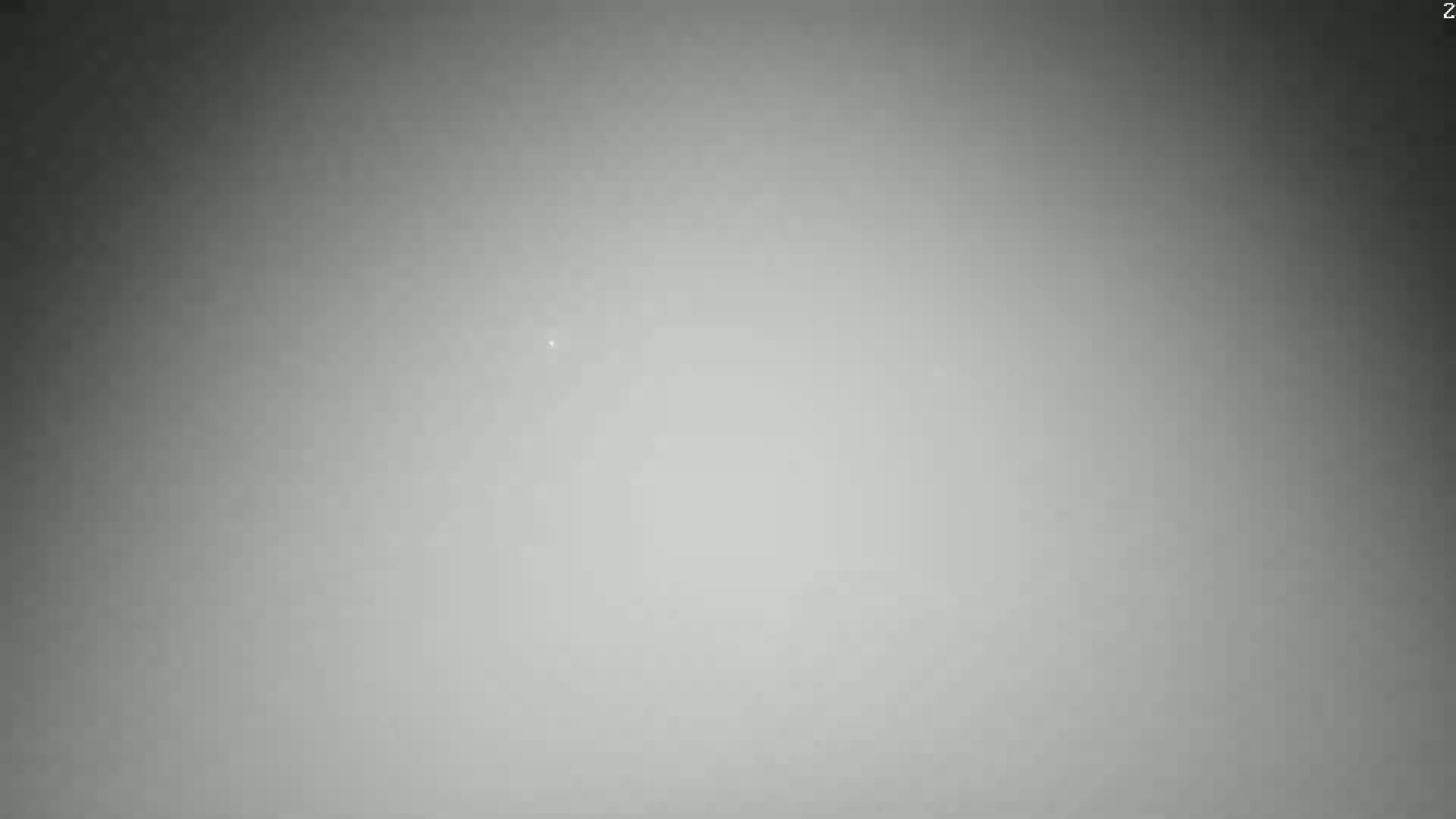 A hazy, gray-toned image shows a mostly featureless scene with a slight brightening in the center.