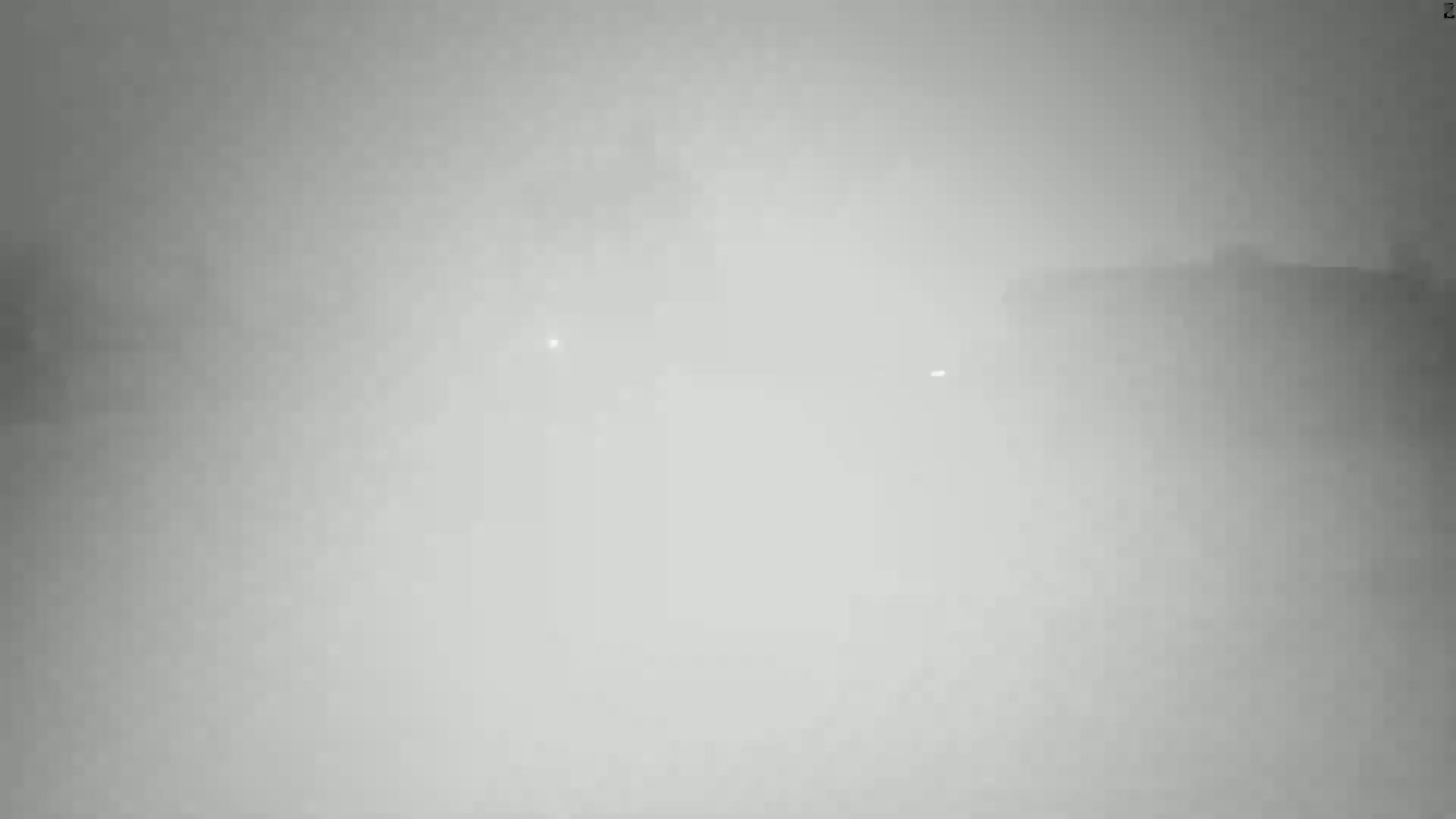 A hazy, foggy scene shows indistinct shapes in the far distance.