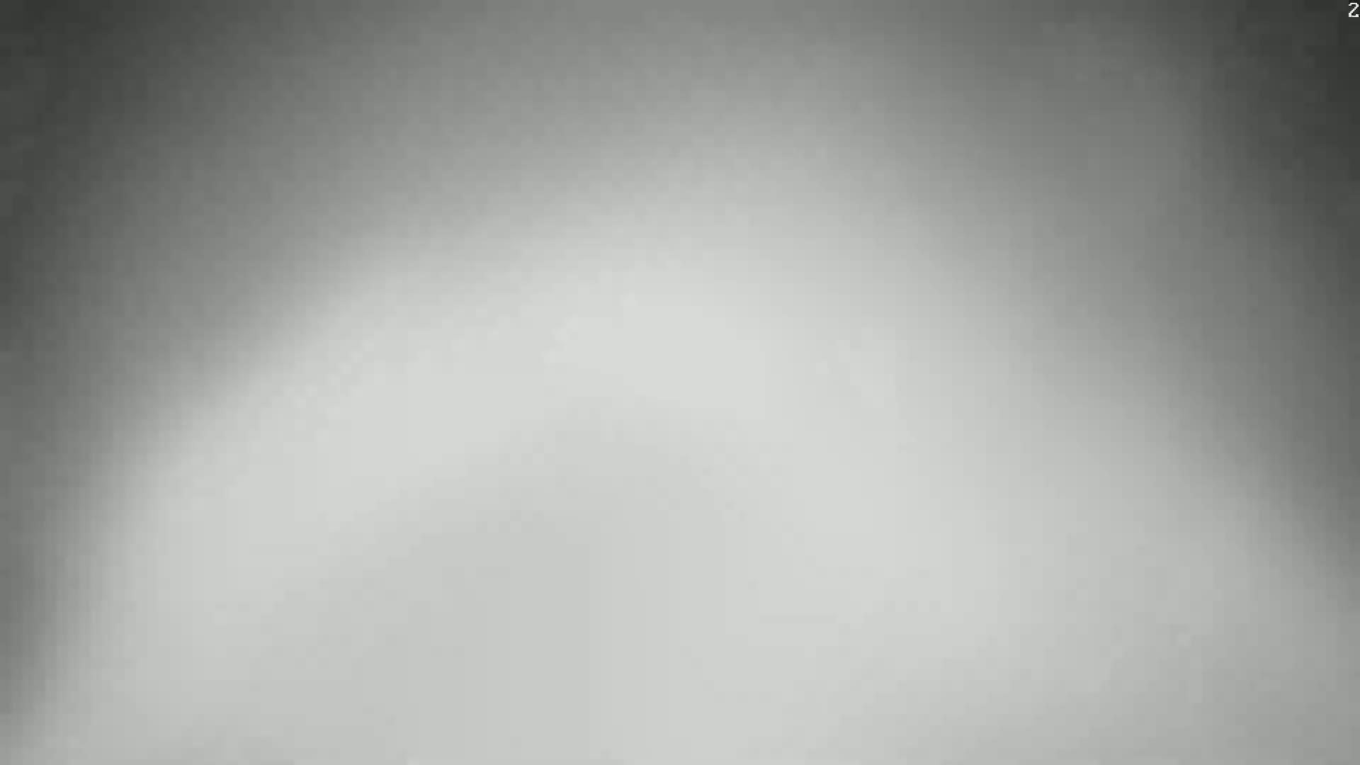 The image shows a blurry, grayscale background with a lighter center and darker edges.