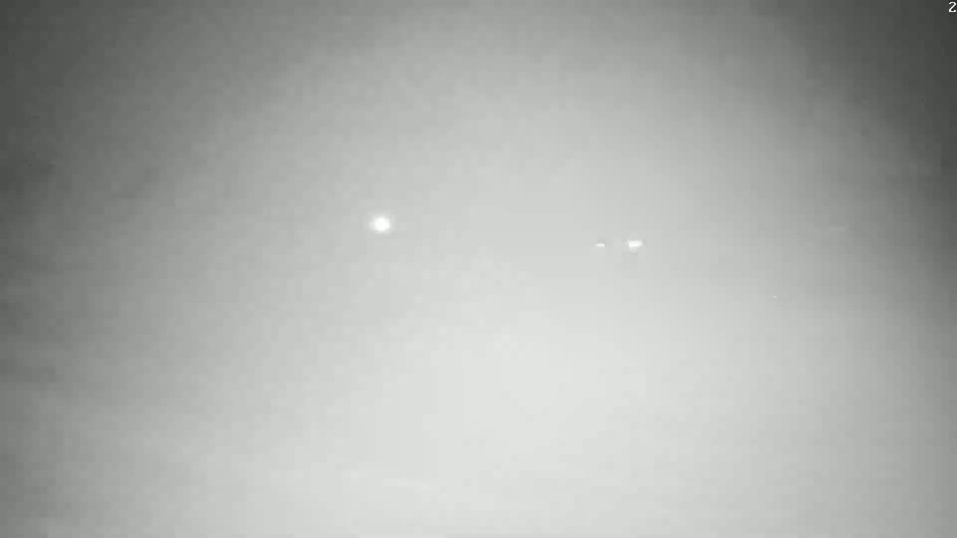 A hazy, gray sky is visible with a few distant lights.