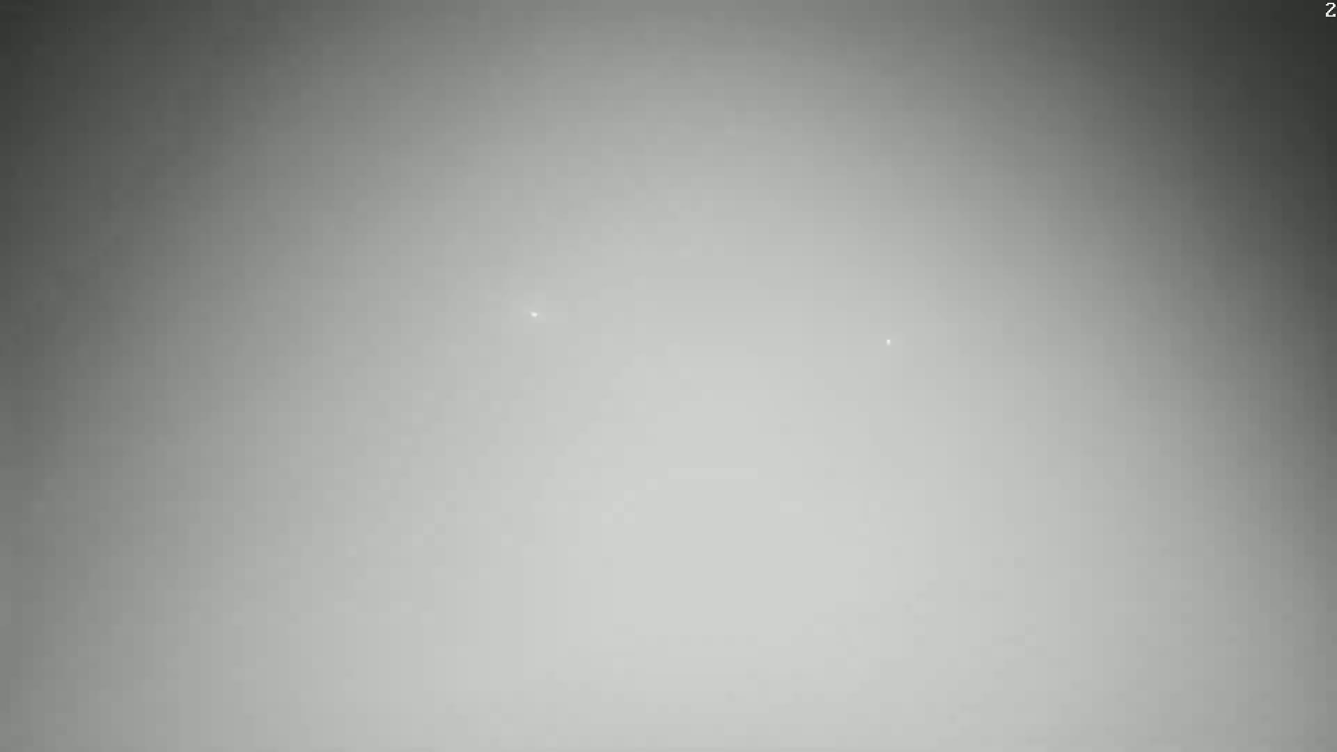 A mostly gray and hazy sky shows two faint, distant lights.