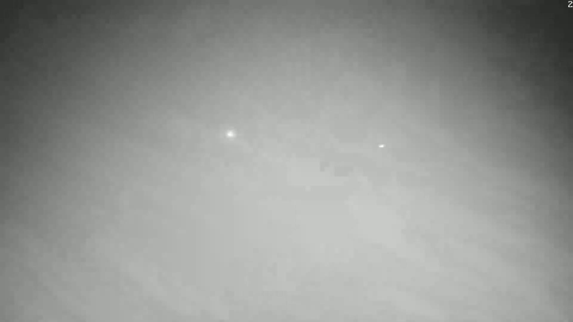 Two indistinct lights are faintly visible through a dense fog.