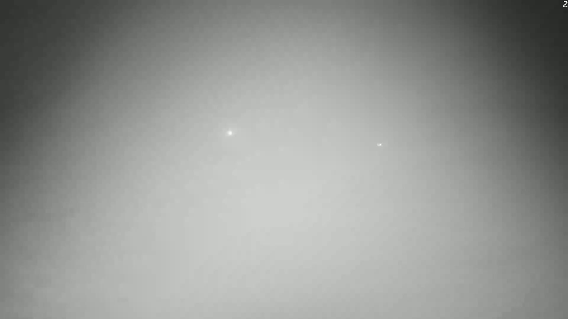 Two faint lights are visible in a hazy, gray sky.