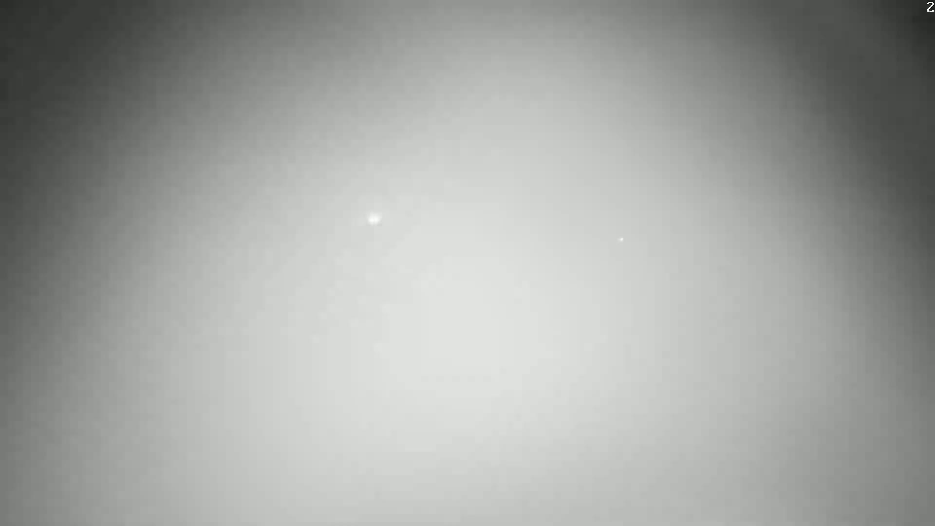 A hazy, gray sky shows two faint, distant points of light.