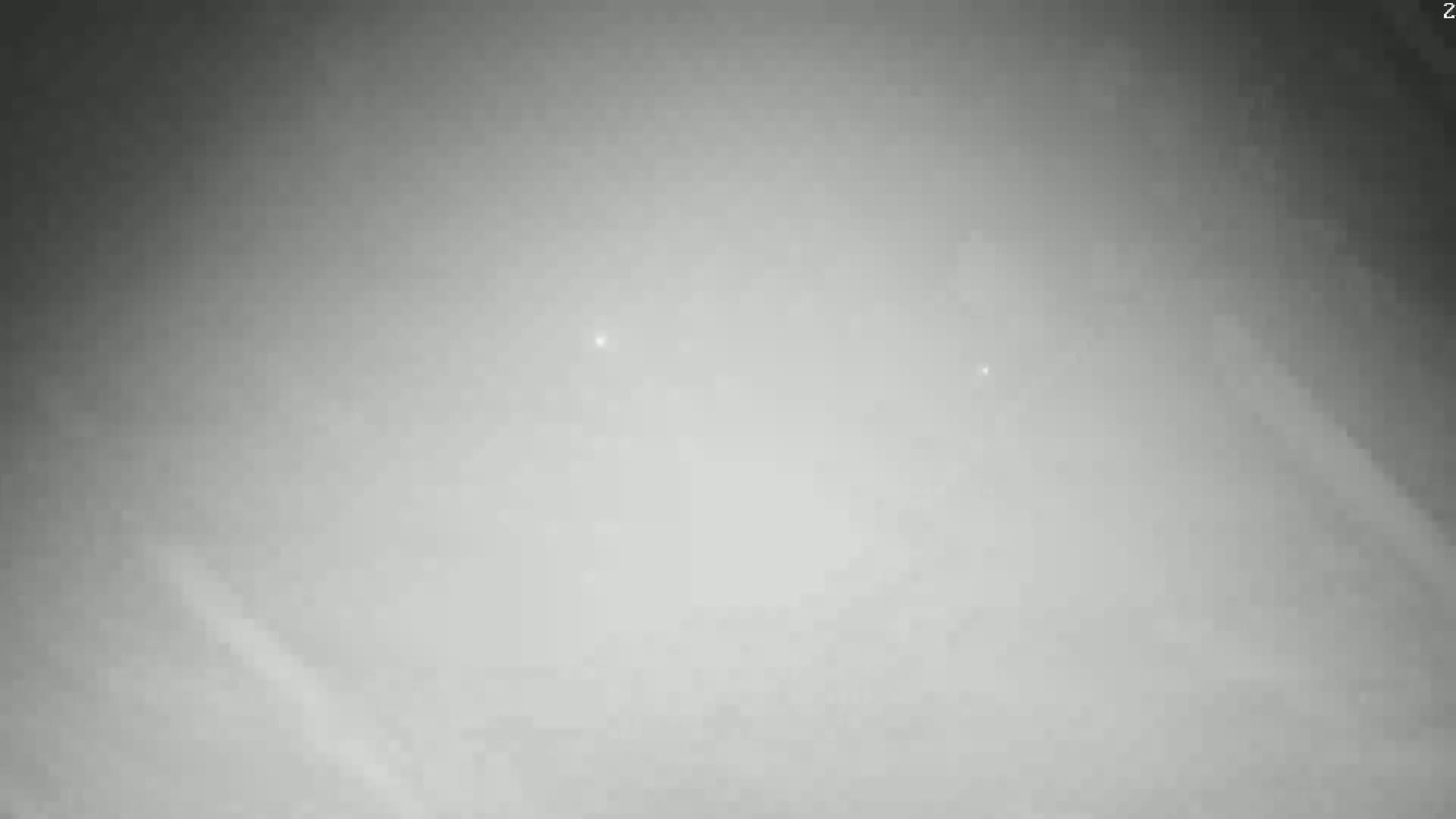A hazy, overcast sky is visible, with a few faint, distant lights.