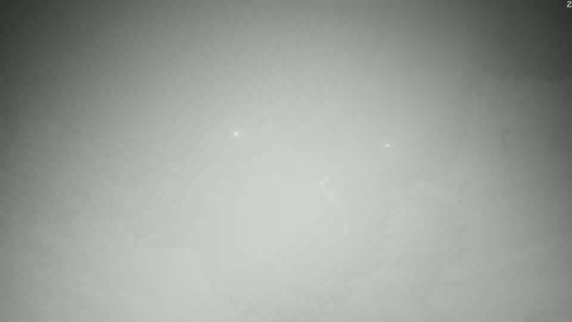 A very hazy or foggy scene is visible, with a few faint, distant specks of light.
