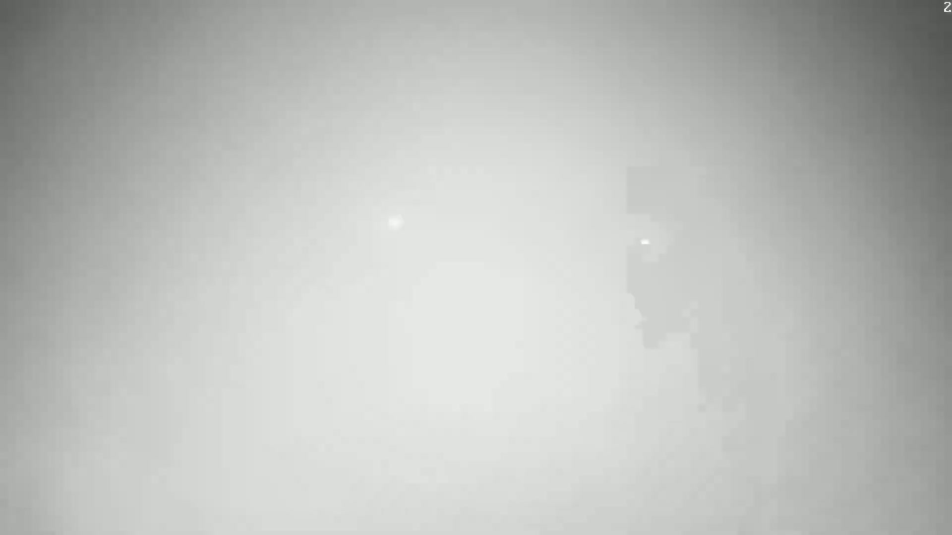 A blurry, mostly featureless, light gray image shows a faint, indistinct shape in the lower right corner under hazy or foggy conditions.