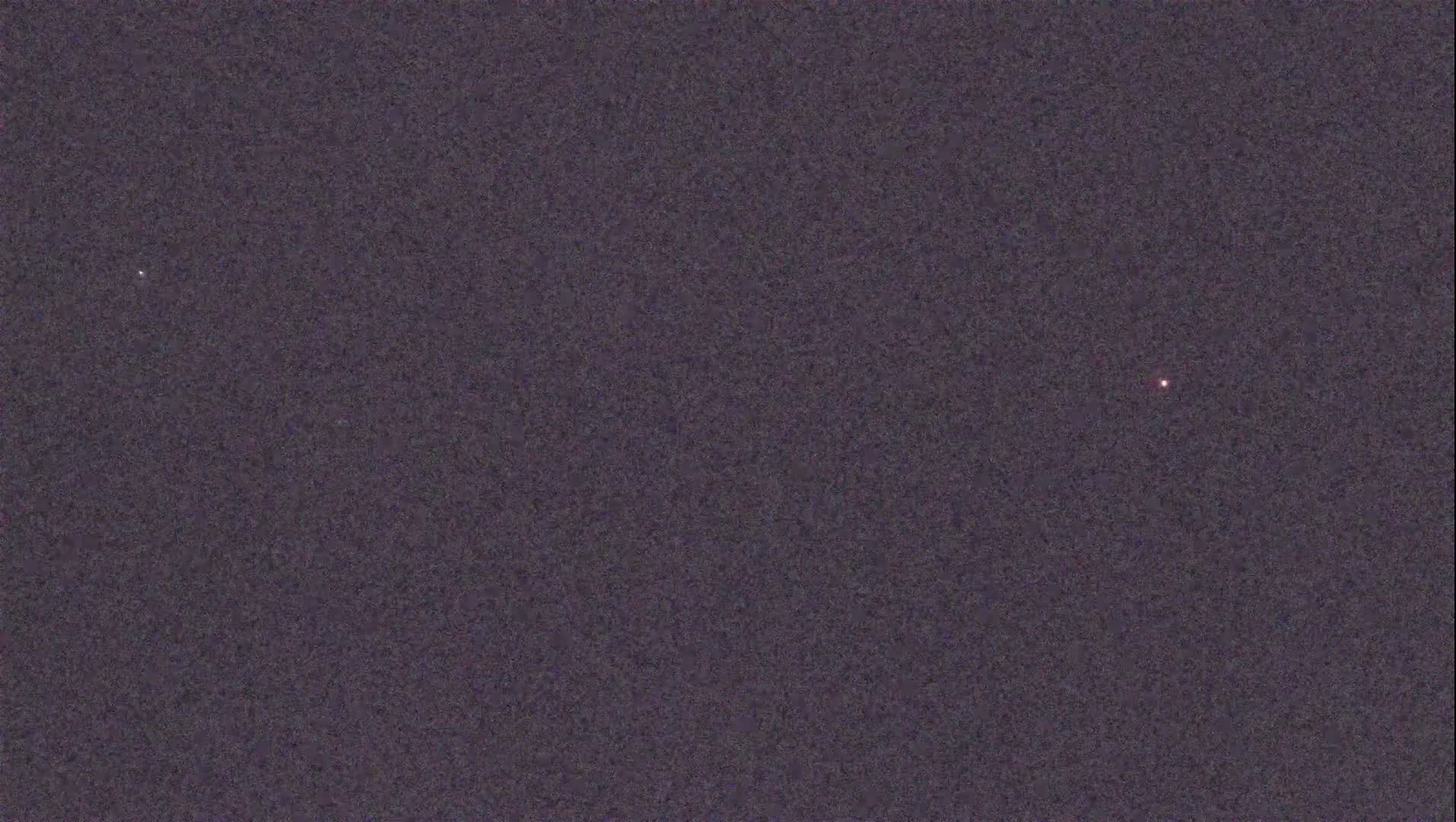 A dark, night sky shows two faint points of light.