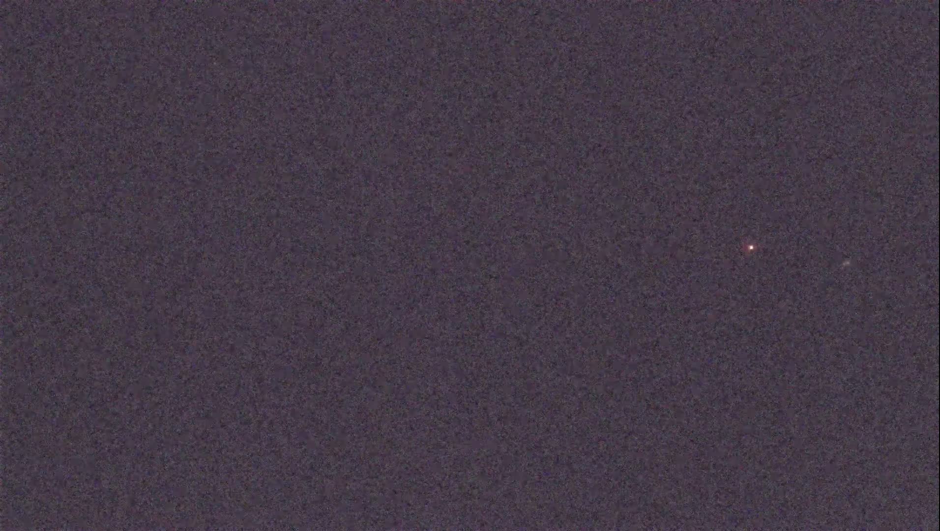 A dimly lit night sky shows two faint points of light.