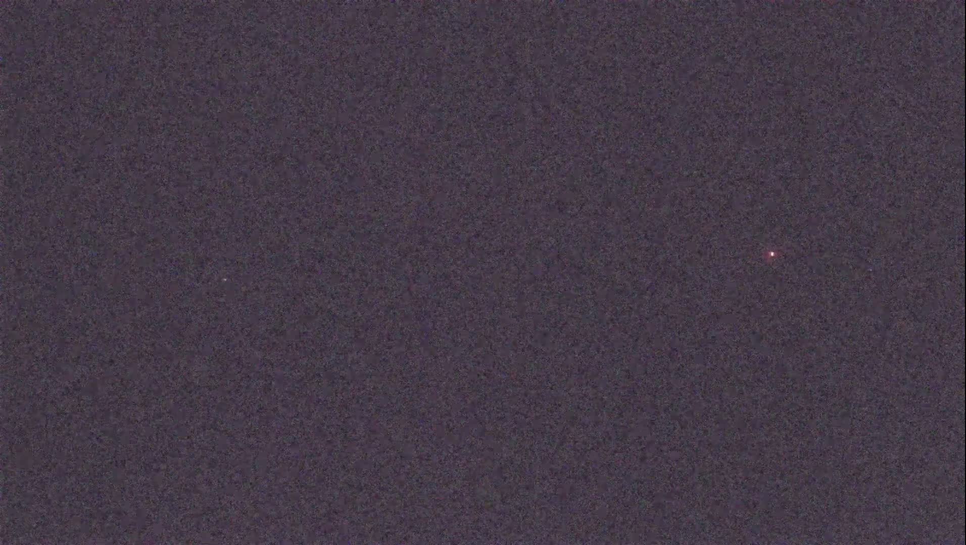 A dark purple, night sky shows a single, faint, reddish light.