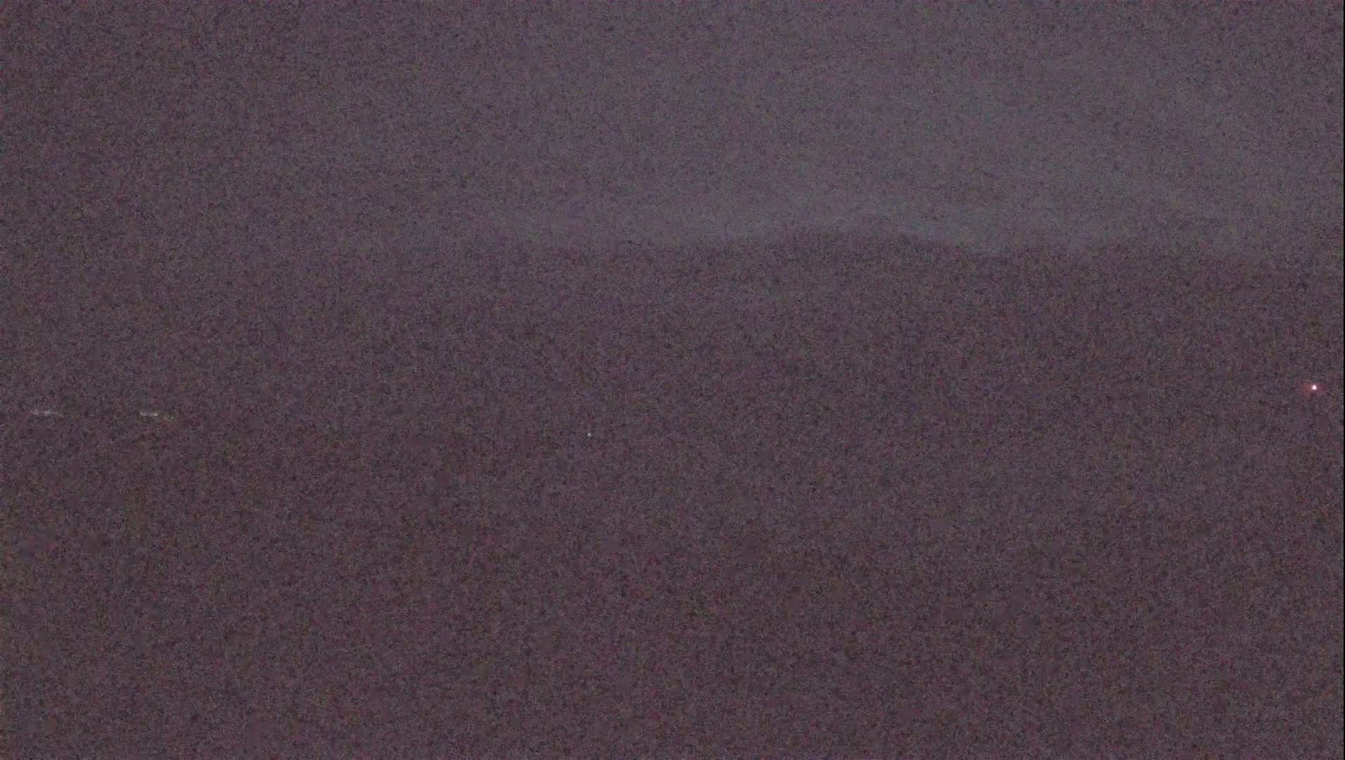 A dark, blurry landscape is visible under an overcast sky.