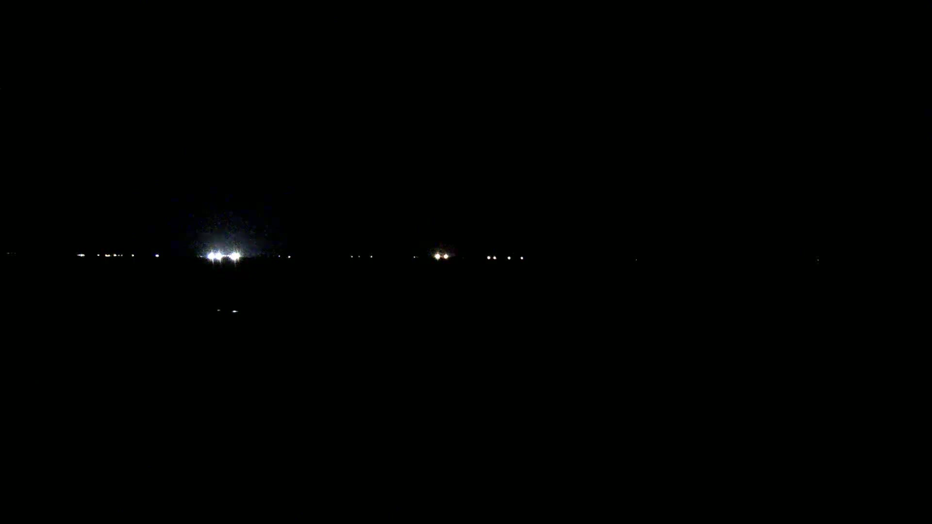 Faint lights from distant vehicles are visible in the inky blackness of the night.