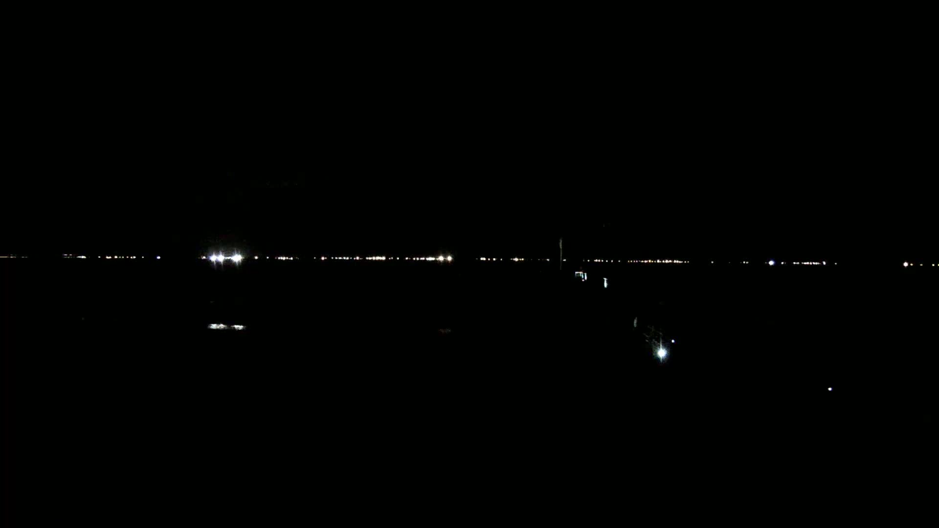 A distant line of lights is visible on a dark, nighttime horizon.