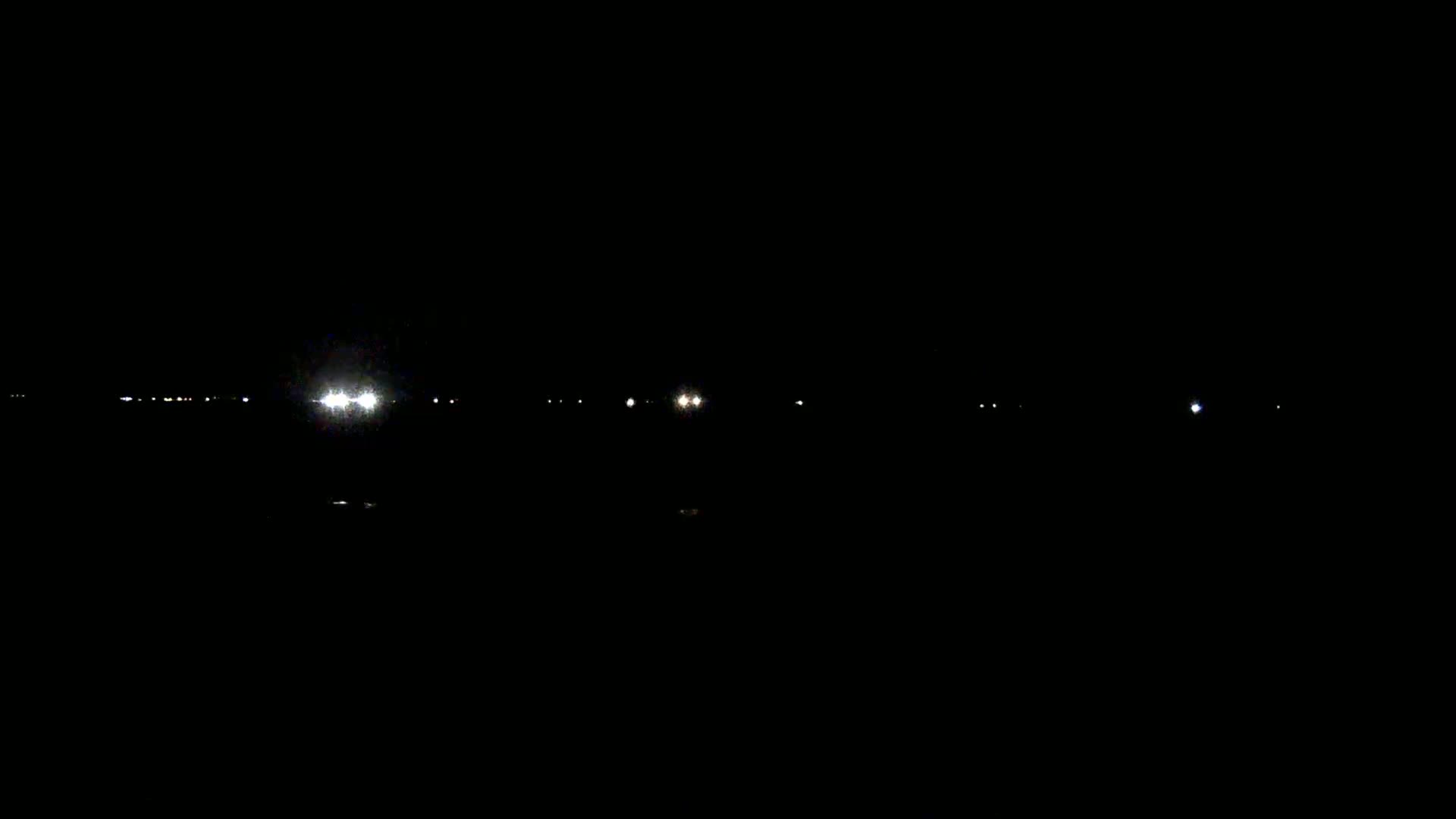 Distant lights are visible in the dark of night.
