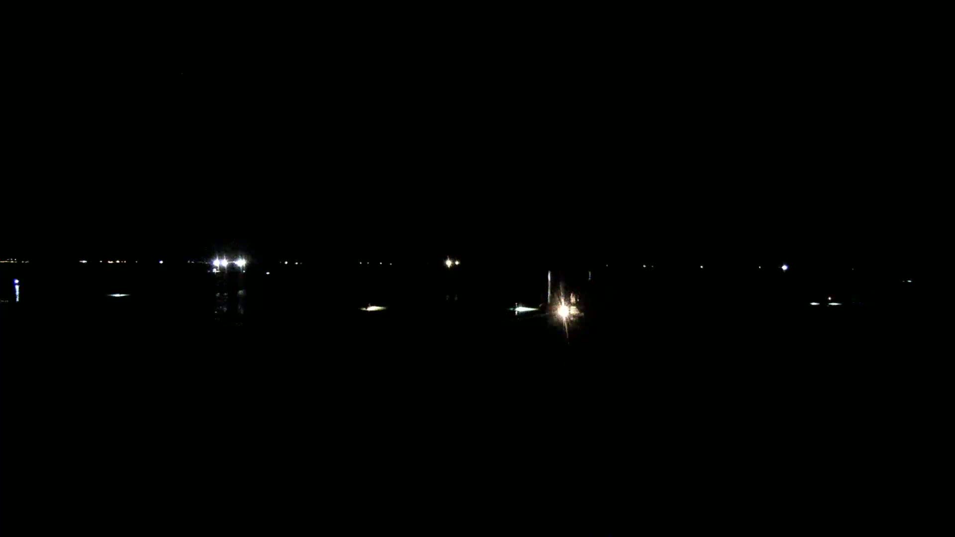 Faint lights are visible on a dark body of water at night.