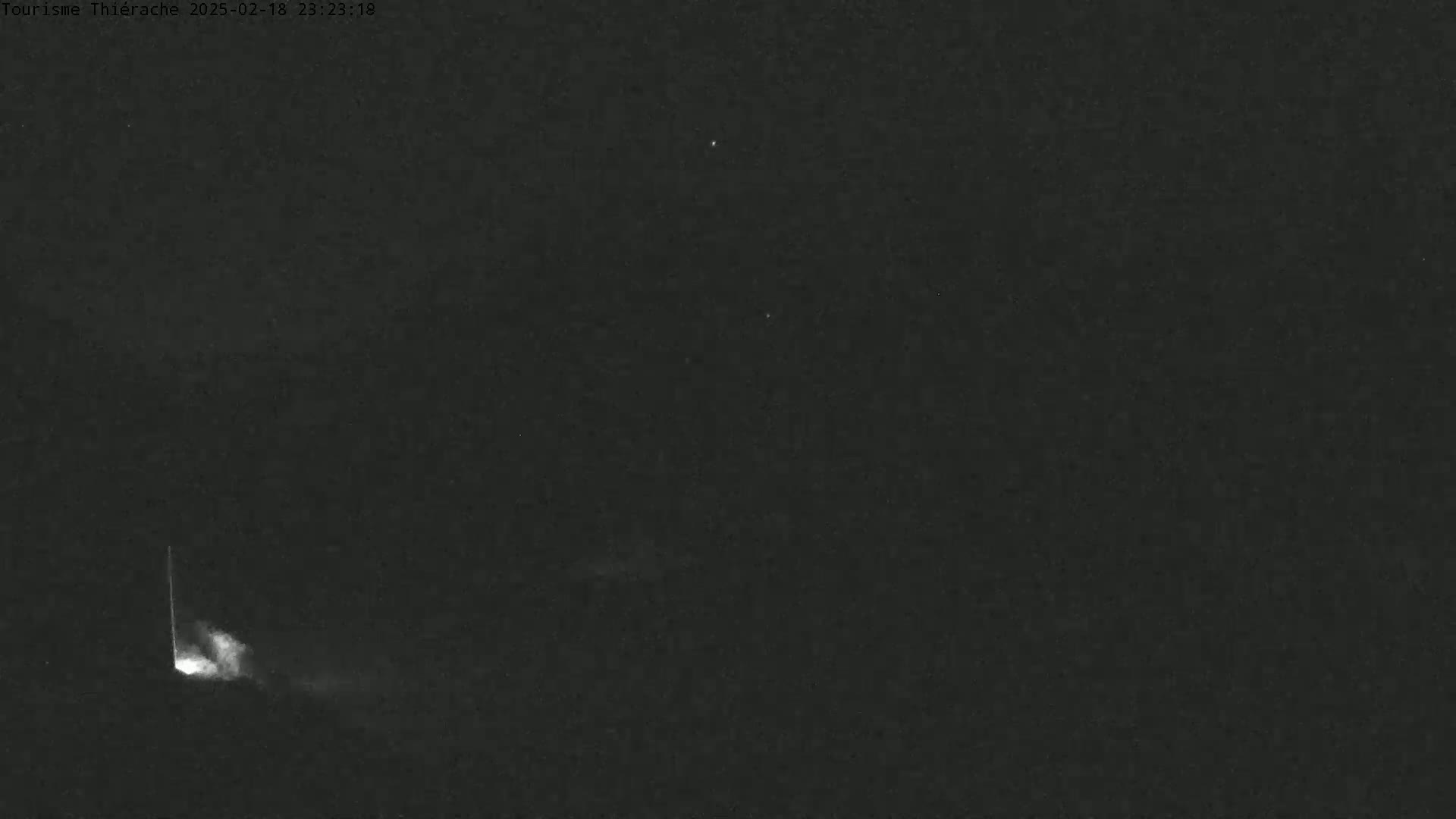 A bright meteor streaks across a dark night sky.