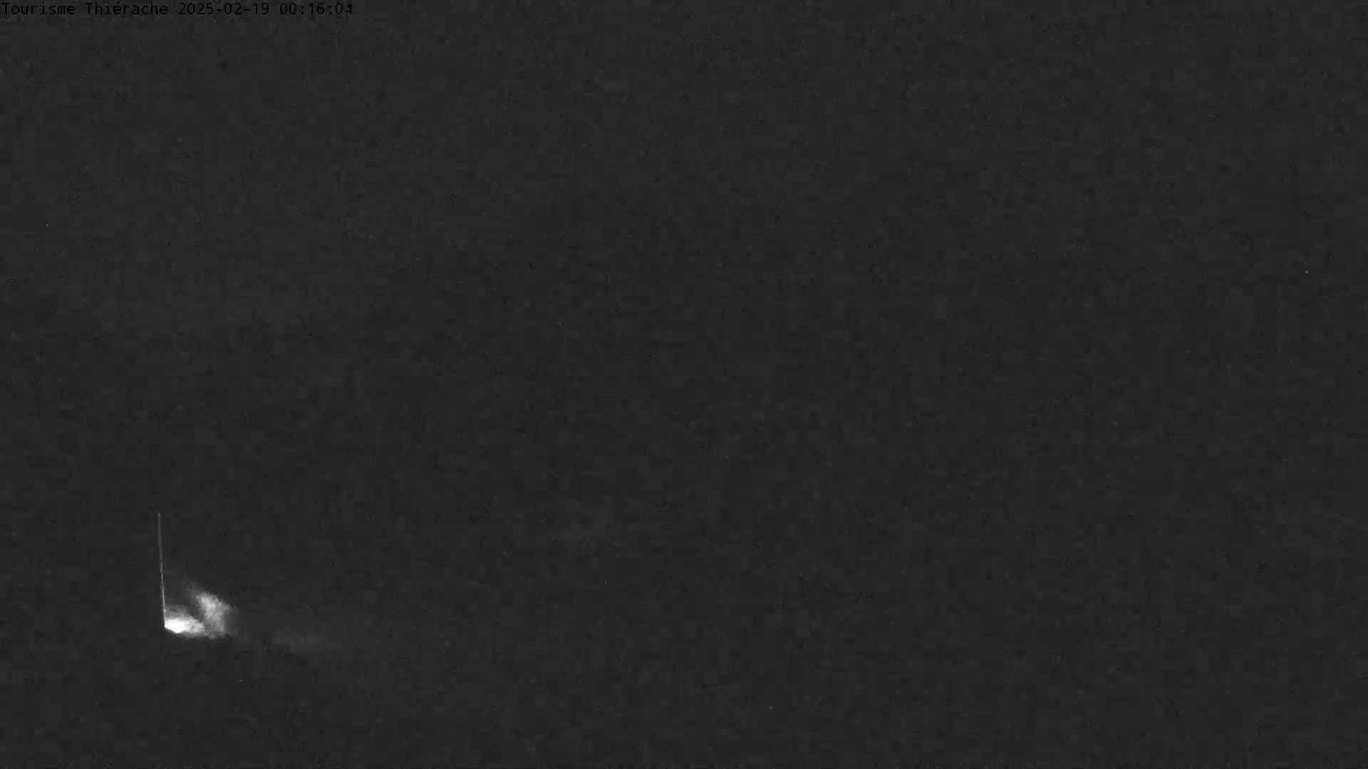 A bright streak of light, possibly a meteor, is visible against a dark night sky.