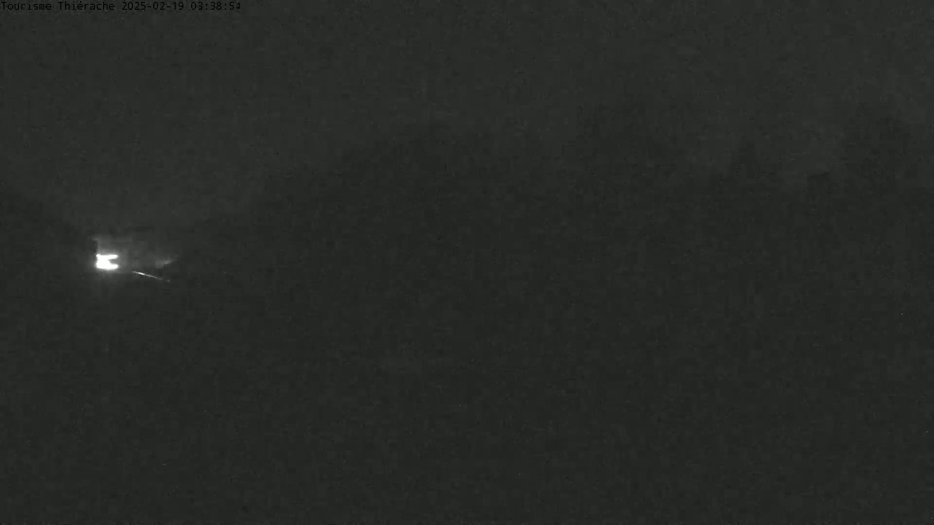 A bright light streaks across a dark, nighttime sky.