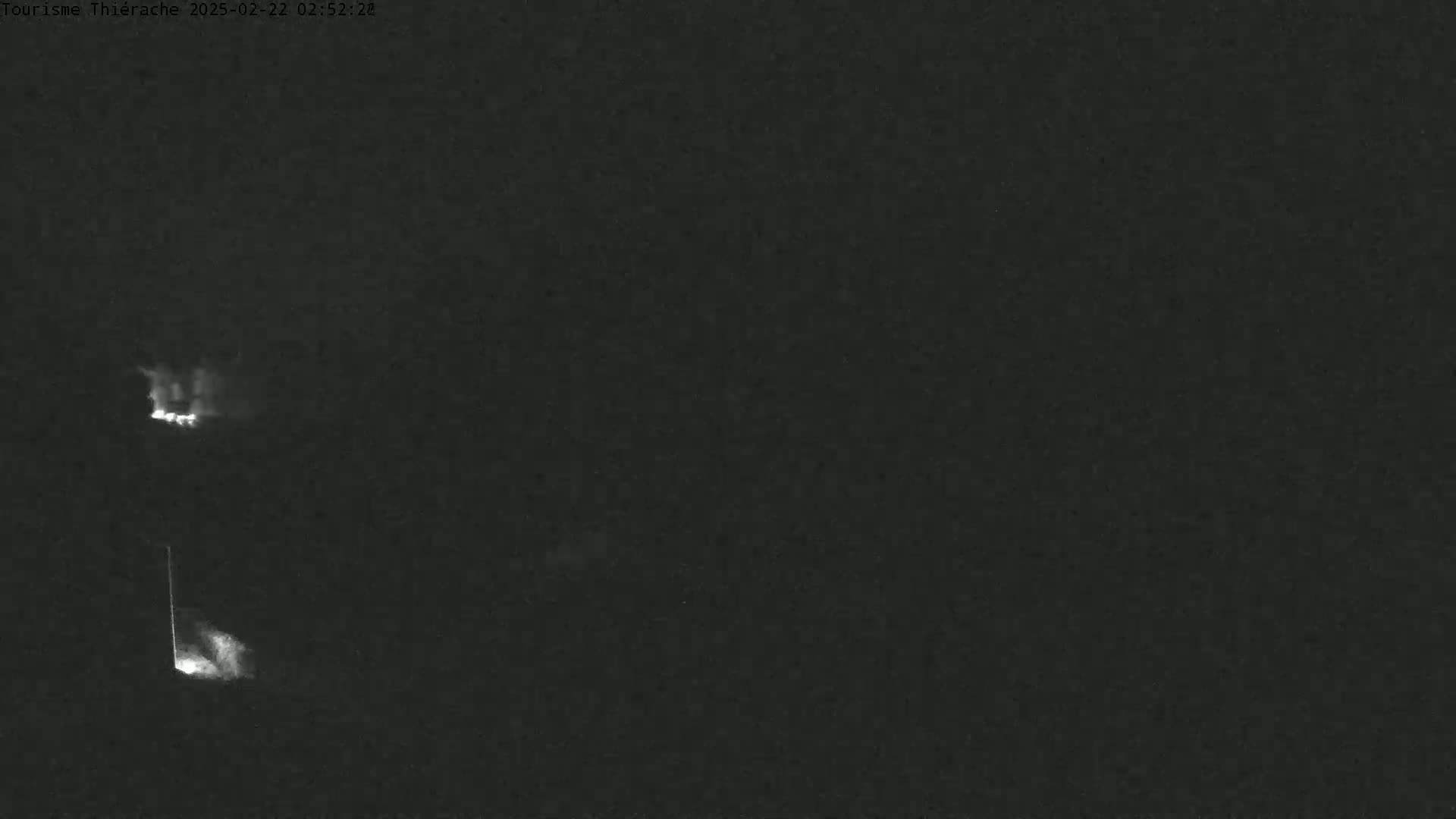 Two faint, bright lights are visible in the dark, possibly indicating distant flames or lights at night.